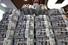 An official checks U.S. dollar notes at a bank branch of Hana Bank in central Seoul on March 31. [YONHAP]