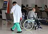 A doctor walks past a patient on a wheelchair in a general hospital in Seoul on Thursday. [YONHAP]