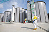 A worker wearing a protective suit and a mask looks up at storage tanks for radioactive water, under construction in the J1 area at the Tokyo Electric Power Company's (Tepco) tsunami-crippled Fukushima Daiichi nuclear power plant in Okuma, Fukushima prefecture in this file photo. [AFP/YONHAP]
