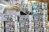 A banker checks dollars at Hana Bank's Counterfeit Notes Response Center in Seoul. [NEWS1]