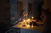 A family eats a snack by candlelight during a blackout in Barcelona, Spain, on April 28. [AP/YONHAP]