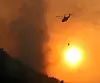 A helicopter pours water on the wildfire in Sangcheong County, South Gyeongsang, on March 23, three days after the fire started. [YONHAP]