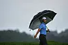 Tom Kim uses an umbrella as he walks down the 18th fairway during the third round of the U.S. Open golf tournament at Oakmont Country Club in Oakmont, Pennsylvania, on June 14. [AP/YONHAP]