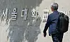 A passerby walks past the main gate of Seoul National University in Gwanak District, southern Seoul, on May 21. [NEWS1]