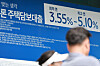 Pedestrians walk by a banner advertising home mortgage loan products at a bank in Seoul on Sept. 7. [YONHAP]