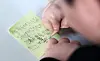 A child writes a memo at an elementary school in Dongdaemun District, central Seoul, on Dec. 24. The message reads, 'I want to work out, get up early, sleep early and eat healthy during the winter vacation.' [NEWS1]