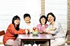 Creators and models of the children's book ″If You Want to Eat a Red Apple″ (2024) pose for photos at photographer Lee Ga-hee's home in Incheon, last month. From left are Lee, her children Ji-gu and Ji-ho and writer Jin Joo. [JOONGANG ILBO]