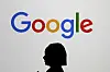 A woman walks by a giant screen with a logo at an event at the Paris Google Lab on the sidelines of the AI Action Summit in Paris, on Feb. 9. [AP/YONHAP]