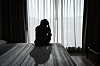 Stock photo of a person feeling depressed and stressed sitting in the dark bedroom. [GETTY IMAGES]