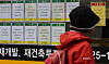A person looks at signs about a bank's loan programs on the exterior of a lender in Seoul. [YONHAP]