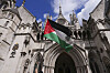 A demonstrator waves a flag outside the High Court in London where a full hearing on an application for a judicial review by Palestine Action against its impending proscription is being heard on July 21. [AP/YONHAP]