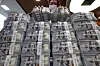 An official checks U.S. dollar notes at a bank branch of Hana Bank in central Seoul on March 31. [YONHAP]