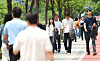 People stroll along the Cheonggyecheon, a stream that flows through central Seoul, on May 20 with their jackets slung over their arms. [YONHAP]