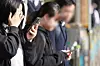 Students are seen on their phones on a street in front of a middle school in Seoul on Nov. 4, 2024. [YONHAP]