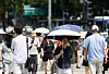 People cross the street at Gwanghwamun Square in central Seoul on July 25 as a heat wave warning remains in effect for most parts of Korea. [JOONGANG ILBO]