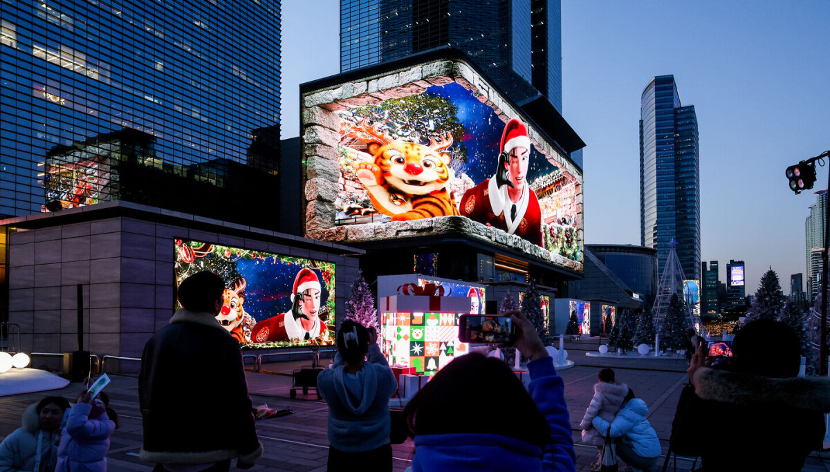 People watch digital LED signages displaying a Christmas themed video featuring Seoul city mascot Hechi in a Rudolph appearance during the 2025 Gangnam Media Winter Festa near Samseong Station exit 5 in southern Seoul photographed by Woo Sang jo for Korea JoongAng Daily on December 22 2025