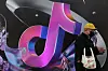 A man stands near a giant sign of Chinese company ByteDance's app TikTok, known locally as Douyin, during China Fashion Week, in Beijing, China, on March 31. [REUTERS/YONHAP]