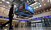 A pedestrian walks by an electronic board displaying closing rates of Korean stock markets at the Korea Exchange headquarters in western Seoul on Dec. 30, 2024. [NEWS1]