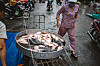 A woman looks at a large pod with fresh fish at street market in Vienh Long, Vietnam, on Nov. 4, 2022. [GETTY IMAGES BANK]