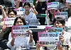 Participants hold up handwritten signs during the ″Rebuild the World Forum″ youth roundtable near Deoksu Palace in Jung District, central Seoul, on May 25. The event gathered 1,000 young people, including university students and teenagers. [YONHAP]