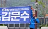 Democratic Party lawmaker Kim Moon-soo removes a promotional banner bearing his name in a photo shared on his official Facebook account on May 11. [SCREEN CAPTURE]
