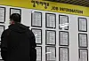 A job seeker checks job postings at an employment center in Seoul on Feb. 20. [YONHAP]