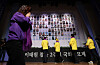 The bereaved family members of safety accidents, which include the Itaewon crowd crush, place white chrysanthemum flowers in front of the victims' photos at a memorial ceremony held at the National Assembly in Yeouido, western Seoul, on Tuesday. [JOINT PRESS CORPS]