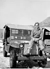 Des Vinten sitting on the bonnet of his jeep. 'The 40 on the windscreen was the Tac Sign for 1 Britcom Divisional Signal Regiment, the Kiwi says I am a Kiwi dispatch rider and the vehicle number D11 tells every one I am a dispatch rider and should not be delayed when on the road,' he said. [DES VINTEN]