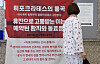 A patient reads a poster criticizing striking doctors for harming patients and burdening other health workers at Seoul National University Bundang Hospital in Gyeonggi on Sunday. [NEWS1]