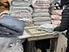 A merchant vacuum-seals a blanket for a customer at Gwangjang Market in Jongno District, central Seoul, on Dec. 22. [KWAK JOO-YOUNG]