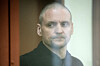 Sergei Udaltsov, Russian left-wing political activist, stands behind a glass in a cage in a courtroom prior to a session in Moscow, Russia, on April 21. [AP/YONHAP]