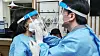 People Power Party presidential candidate Ahn Cheol-soo, right, and his wife, Seoul National University professor Kim Mi-kyung, put on protective suits before beginning volunteer medical service at a Covid-19 testing site in Jung District, central Seoul, in 2020. [YONHAP]
