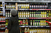 A customer selects from different cooking oils displayed at a supermarket in Seoul on Thursday. [NEWS1]
