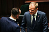 Newly appointed Polish Prime Minister Donald Tusk, pictured right, talks with Polish MP Janusz Kowalski of Sovereign Poland during a parliamentary session break in Warsaw on Tuesday. [REUTERS/YONHAP]