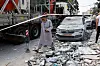 A man walks near damaged vehicles and debris after missiles fired from Iran struck a residential building in Tamra, Israel, on June 15. [REUTERS/YONHAP]