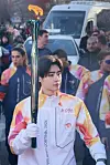 Sunghoon of K-pop group Enhypen holds the Olympic torch for the Milano Cortina Winter Olympics in Milan, Italy, on Feb. 5. [BELIFT LAB]