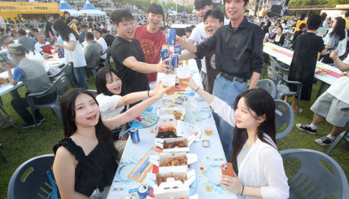 Des visiteurs dégustent du poulet frit coréen et de la bière fraîche (chimaek) au festival Daegu Chimac 2024 au parc Duryu le 3 juillet 2024, photographié par NEWS1 pour la couverture par le Korea JoongAng Daily du festival qui attire plus d'un million de participants chaque année et célèbre Daegu comme le berceau de nombreuses franchises de poulet frit coréen.