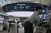 A currency trader watches monitors near a screen showing the Kospi, top center left, and the foreign exchange rate between dollar and won, top center, at the foreign exchange dealing room of the KEB Hana Bank headquarters in Seoul on April 11 [AP/YONHAP]