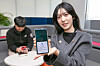 A person holds a phone displaying KT's alerts service against suspected text message scams, on Dec. 17, 2024. [KT]