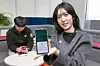 A person holds a phone displaying KT's alerts service against suspected text message scams, on Dec. 17, 2024. [KT]