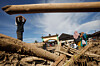 Survivors walk past logs swept away by a flash flood in Batang Toru, North Sumatra, Indonesia, on Dec. 2. [AP/YONHAP]
