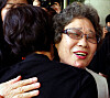 Seventy-eight-year-old Choi Mal-ja, who was found guilty of injuring a man who tried to rape her 61 years ago, hugs a civic organization member in joy as she exits a courtroom at the Busan District Court on July 23 after prosecutors made a public apology toward Choi on the same day. [YONHAP]