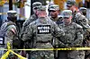 National Guard members stand together behind police tape, after two National Guard members were shot near the White House in Washington on Nov. 26. [REUTERS/YONHAP]