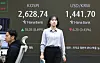 A person passes by a screen in Hana Bank's trading room in central Seoul on March 18. [YONHAP]