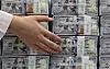 An official checks banknotes at a bank branch of Hana Bank in central Seoul on on June 5. [YONHAP]