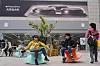 Shoppers balance themselves on wobbling seats near a store selling Apple products in Beijing, China on April 8, 2025. [AP/YONHAP]
