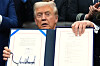 U.S. President Donald Trump displays the signed the funding bill to reopen the government, in the Oval Office of the White House on Nov. 12 in Washington. [AP/YONHAP]