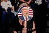 An attendee holds a paddle sign with an image depicting Donald Trump as they attend his ″Make America Great Again″ rally in Latrobe, Pennsylvania, on Oct. 19, 2024. [REUTERS/YONHAP]