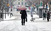 A person walks on a snow covered street holding an umbrella in Jongno District, central Seoul, on Feb. 12. [YONHAP]