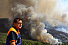 A civil protection officer watches a wildfire burning in the village of Gramaca, Oliveira do Hospital municipality, central Portugal, on Aug. 13. The fire, which started in the nearby village of Piodao, has spread to neighbouring Arganil and other areas prompting the deployment of more than 600 firefighters. [EPA/YONHAP]